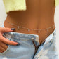 Delicate silver belly chain with crystal drops, worn with fuzzy yellow crop top and light denim jeans