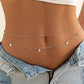 Layered gold belly chain with charms, worn with denim shorts and white top for women's fashion