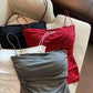 Women's ruched camisole tops in black, red, gray, and white, styled on a cozy armchair for casual fashion.