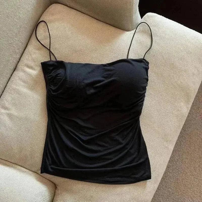 Black ruched camisole top with thin straps on beige couch