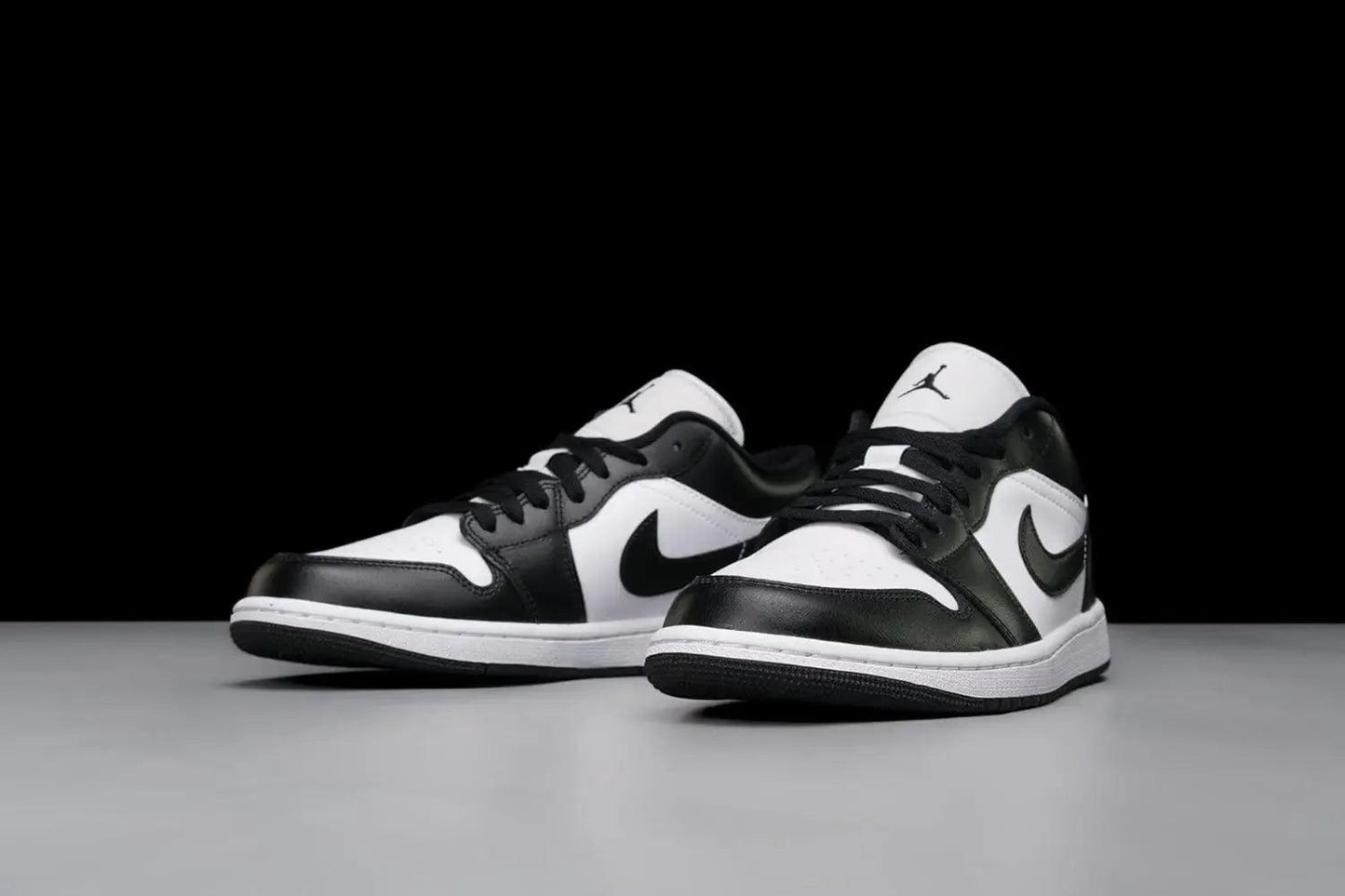 Black and white Air Jordan 1 low sneakers with Nike swoosh, stylish women's fashion footwear