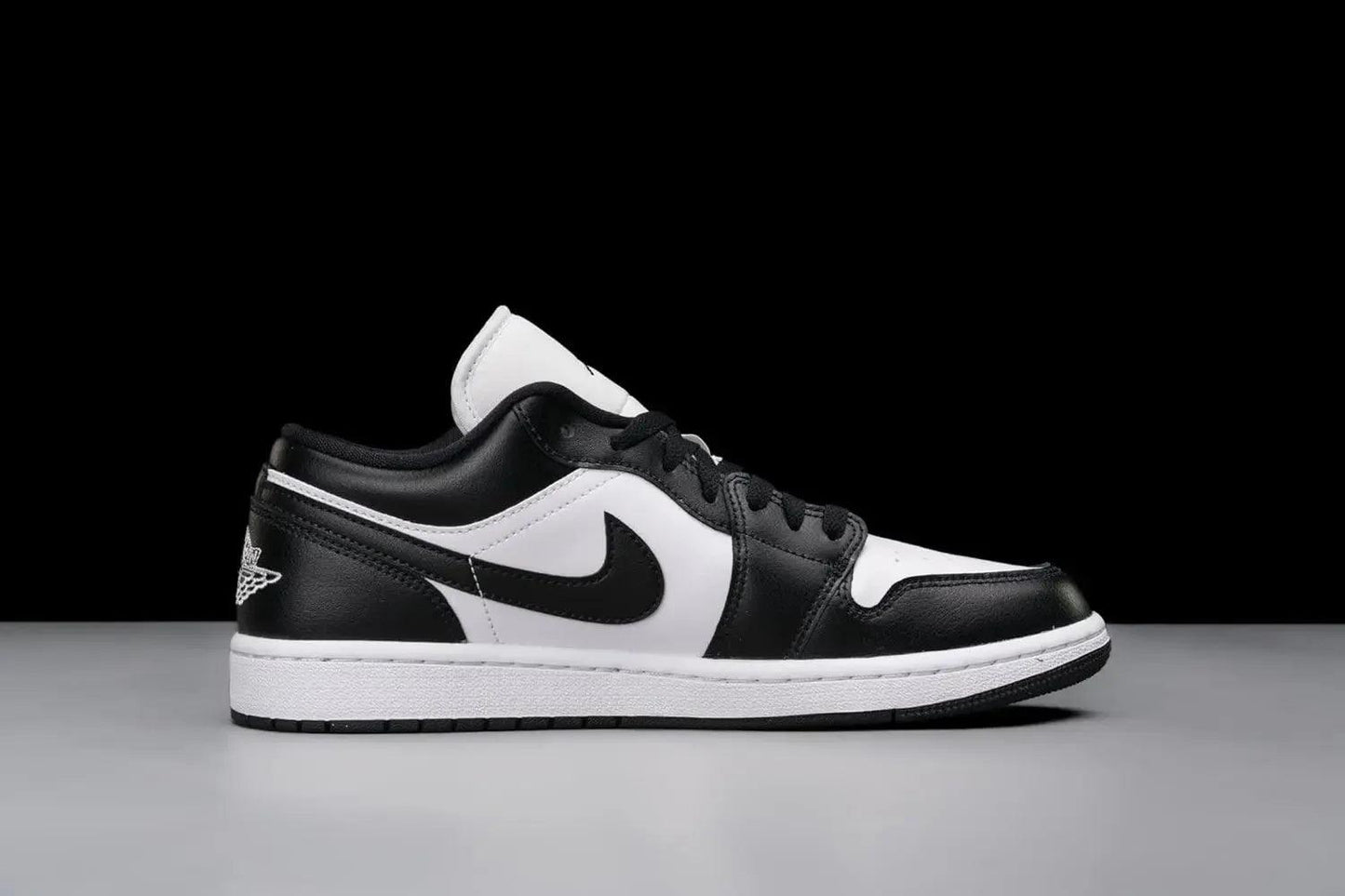 Black and white low-top sneaker with Nike swoosh and Jumpman logo, stylish women's fashion footwear