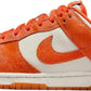 Orange and white Nike Dunk Low sneaker with textured Swoosh, ideal for women's fashion and streetwear styles