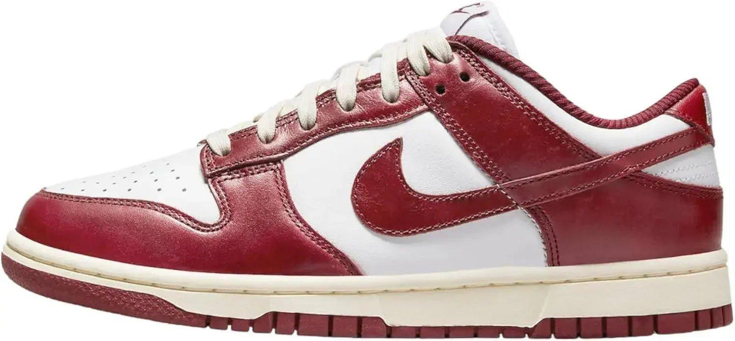 Red and white Nike Dunk Low sneaker with classic leather design and iconic swoosh logo