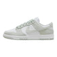 White and light green Nike Dunk Low sneaker with textured panels and classic design