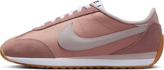 Pink Nike Cortez women's sneaker with white laces and gum sole, retro running shoe style