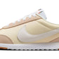 Beige and cream Nike sneaker with white swoosh, suede accents, and gum sole for women's fashion