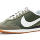 Olive green Nike sneaker with white swoosh, gum sole, and white laces for women's fashion
