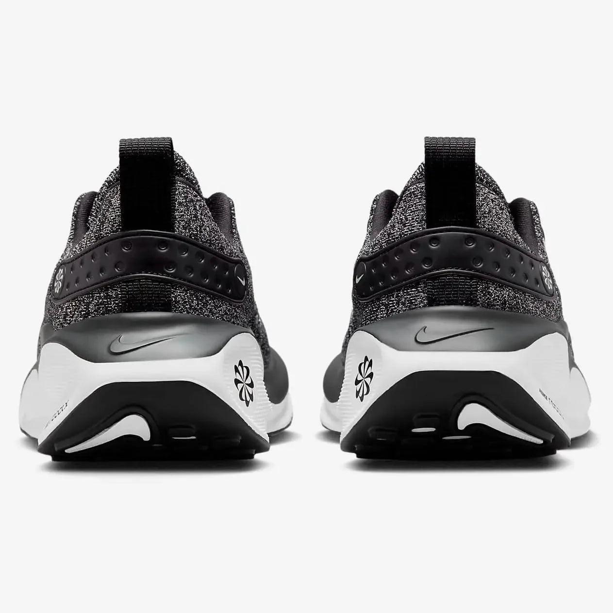 Black and white Nike running shoes with floral design, rear view
