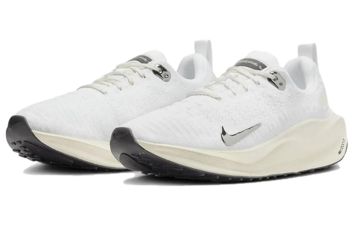 White Nike running shoes with black soles and silver swoosh, lightweight athletic sneakers for women