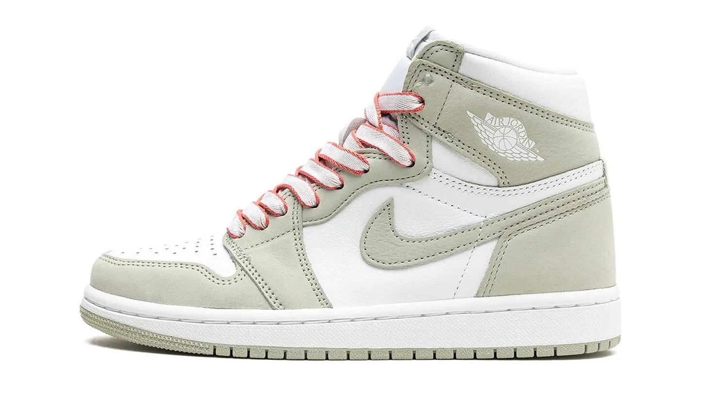 White and sage green Air Jordan 1 high-top sneaker with pink laces, perfect for women's fashion and streetwear style.
