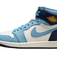 Air Jordan 1 High in light blue, white, and navy with gold logo, stylish women's sneaker