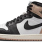 Air Jordan 1 high-top sneaker in black, white, and beige with Nike swoosh and wing logo