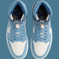 Light blue and white Nike Air Jordan 1 high-top sneakers with perforated toe box and branded tongue