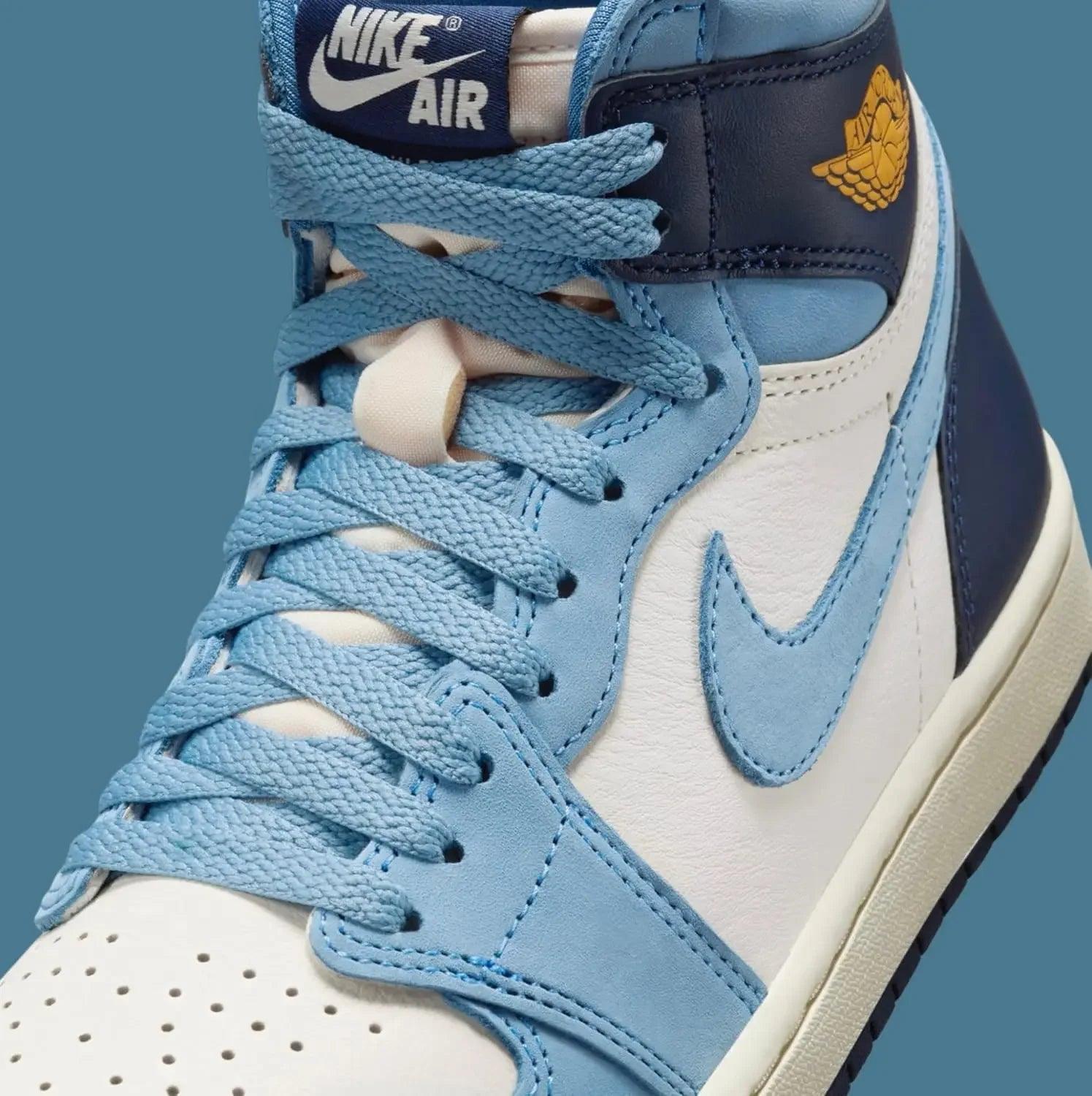 Nike Air Jordan 1 high-top sneaker in light blue, white, and navy with gold wing logo, fashion footwear