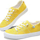 Bright yellow women's canvas sneakers with white laces and frayed edges, casual fashion footwear