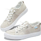 Beige canvas women's sneakers with white laces and frayed edges, casual fashion footwear
