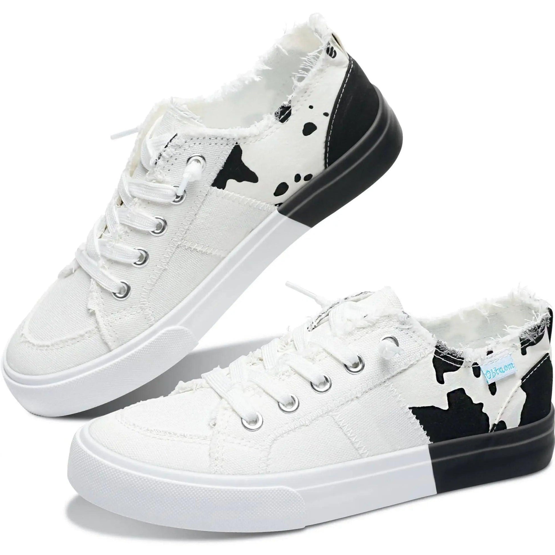 White canvas sneakers with black cow print, frayed edges, and two-tone soles for women's fashion