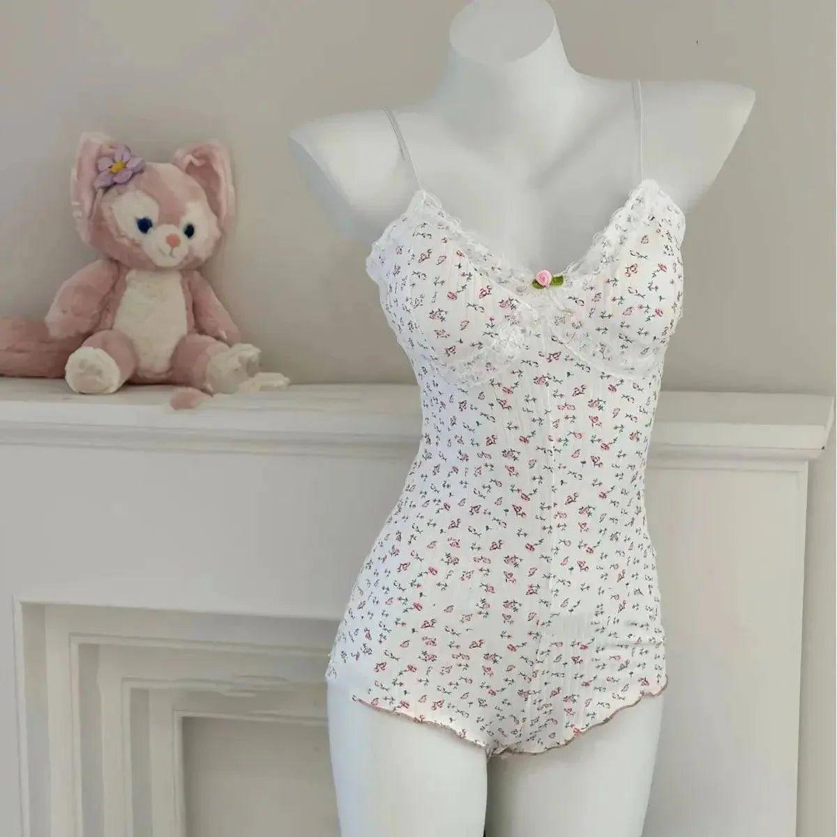 White floral lace camisole with ruffled trim, displayed on mannequin beside plush toy, women's fashion