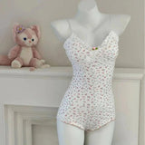 White floral lace camisole with ruffled trim, displayed on mannequin beside plush toy, women's fashion