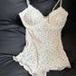 Floral lace-trimmed camisole with ruffled hem, women's fashion sleepwear on black leather