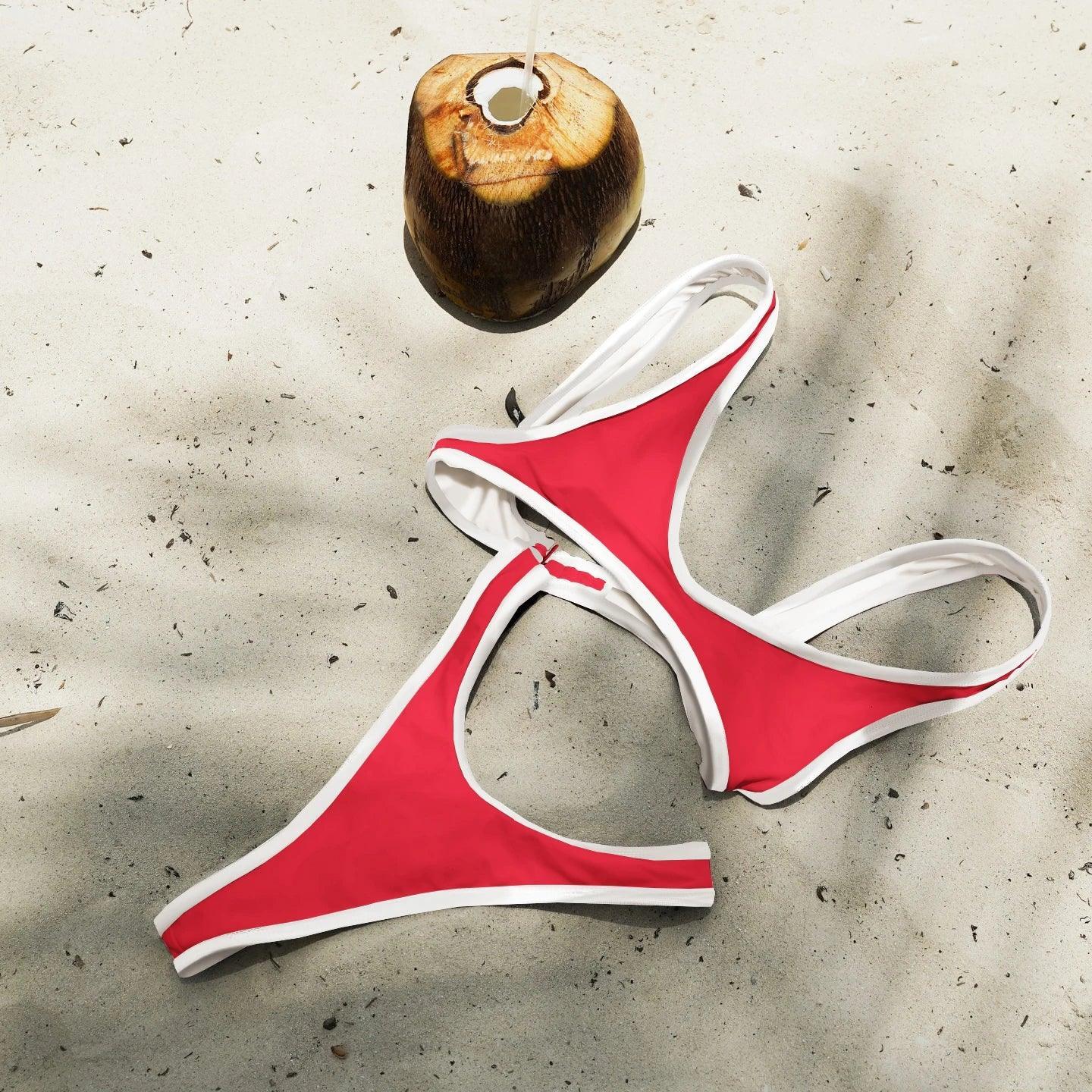 Red and white bikini set on sandy beach with coconut drink, perfect for summer fashion