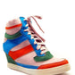 Colorful women's wedge sneaker with blue, pink, orange, and green panels, perfect for fashion-forward styles.