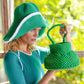Woman in green knit hat and matching crocheted handbag, stylish summer fashion accessory set