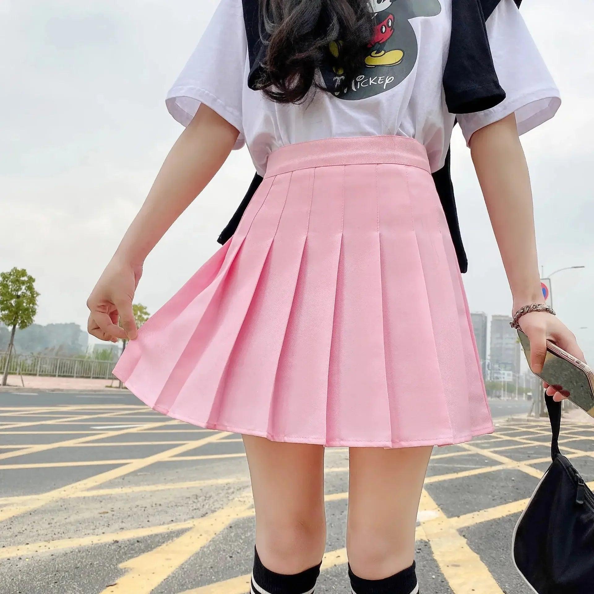 Pink pleated mini skirt with white graphic tee, casual women's fashion outfit