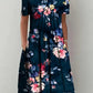 Woman wearing navy floral print dress with short sleeves and pockets, perfect for casual fashion