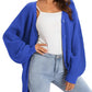 Royal blue knit cardigan with buttons, worn over white top and light jeans, women's fashion