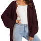 Woman wearing burgundy waffle knit cardigan with white top and light wash jeans, casual fashion outfit