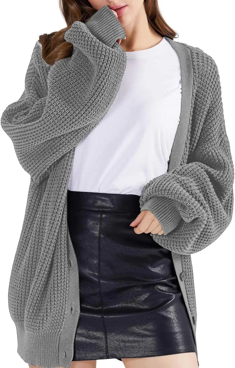 Grey chunky knit cardigan sweater with oversized sleeves, paired with white tee and black faux leather skirt