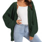 Woman wearing green floral print camisole top with thin straps and pleated detail, paired with jeans