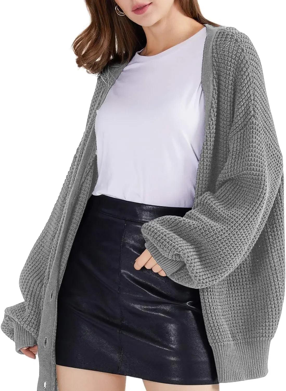 Woman wearing gray waffle knit cardigan over white tee with black faux leather mini skirt, casual fashion