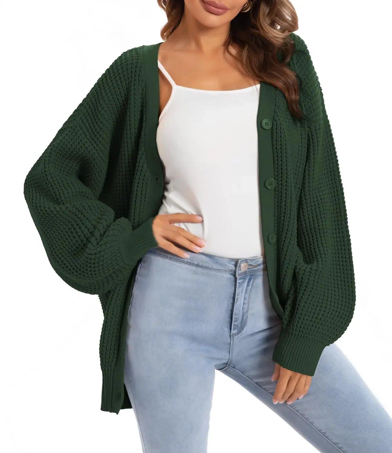 Woman wearing green knit cardigan over white top with light blue jeans, stylish fall fashion