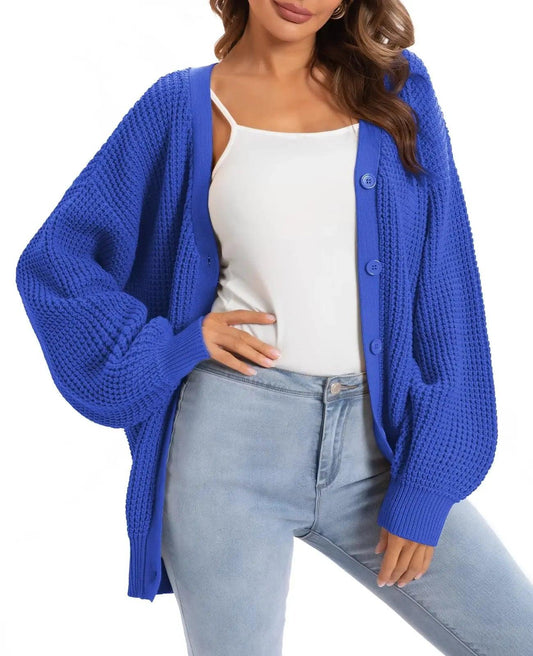 Woman wearing blue knit cardigan with buttons, white top, and light jeans for casual fashion