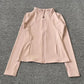 Blush pink women's zip-up athletic jacket with long sleeves and side pockets, ideal for fitness and casual wear