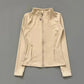Beige women's zip-up athletic jacket with high collar and side pockets, perfect for fitness and casual wear.
