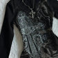 Black gothic dress with silver cross print and rhinestone embellishments, paired with a crystal cross necklace.