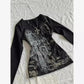 Black long sleeve top with gothic cross print and rhinestone embellishments, styled with silver necklace