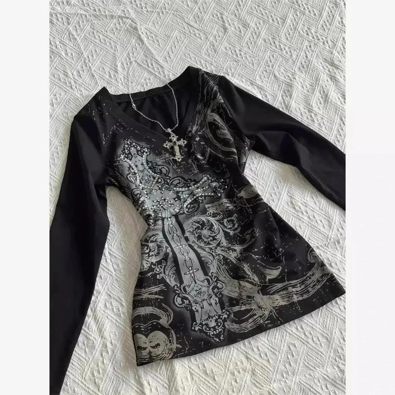 Black long sleeve top with gothic cross print and rhinestone embellishments, styled with silver necklace