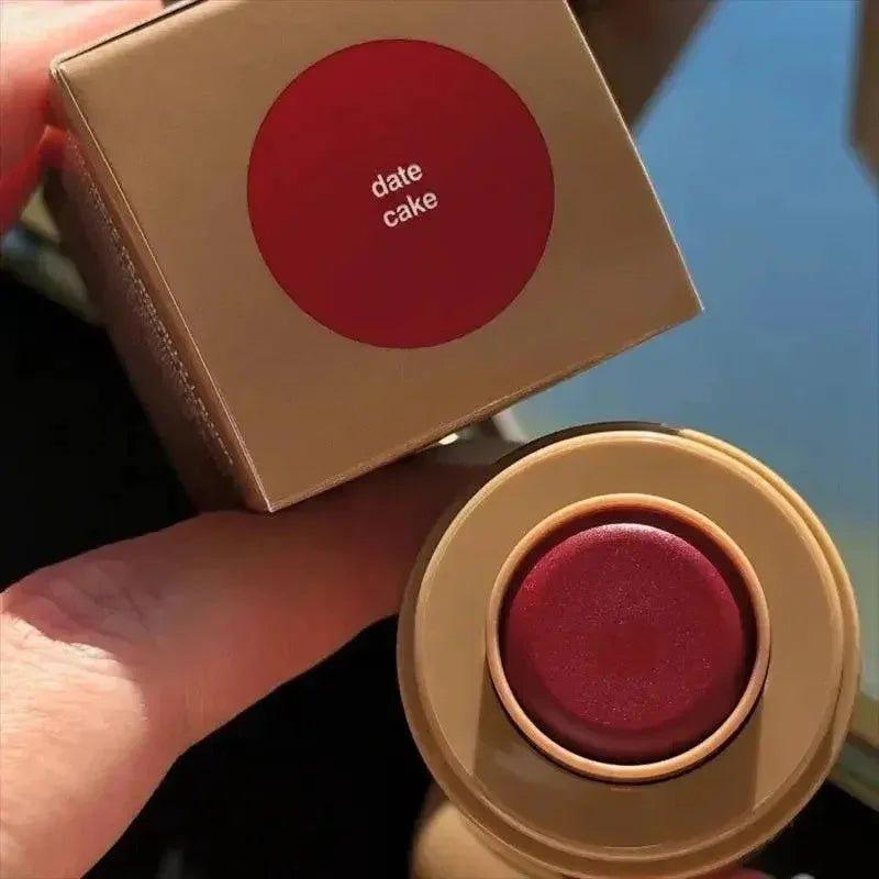 Date Cake matte lipstick in rich burgundy shade, held with gold packaging for women's fashion beauty