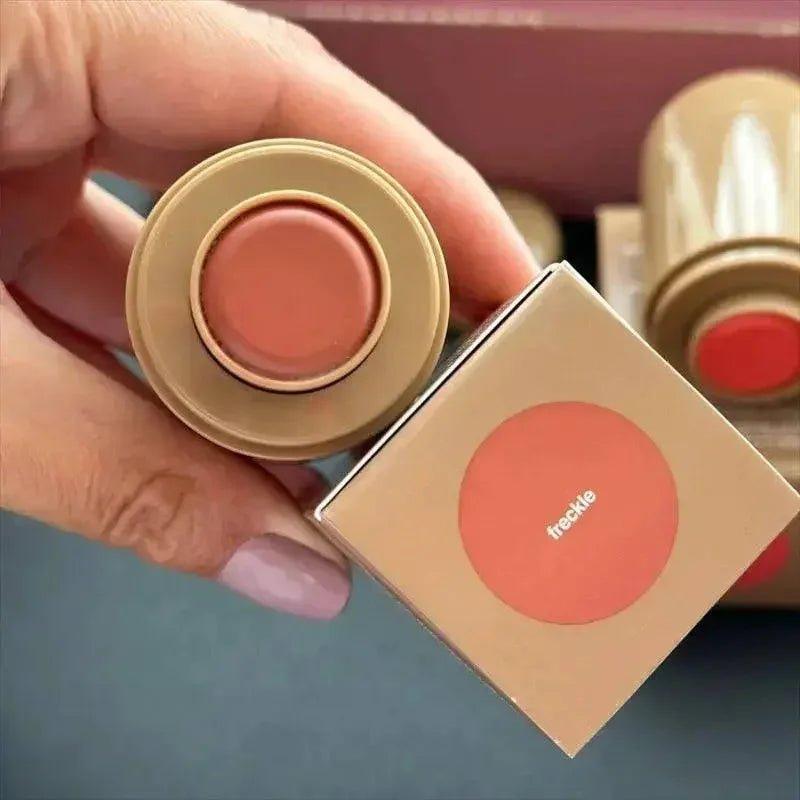 Freckle brand creamy blush in warm peach tone, held with matching box, perfect for women's fashion makeup