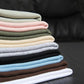 Stack of folded ribbed women's tops in pastel and neutral colors for casual fashion