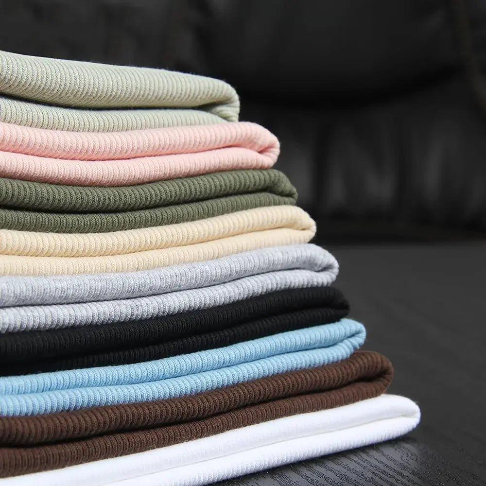 Stack of folded ribbed women's tops in pastel and neutral colors for casual fashion
