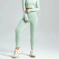 Mint green women's long sleeve crop top and high-waisted leggings with white chunky sneakers
