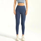 Woman wearing high-waisted navy blue leggings with gray sports bra and white sneakers