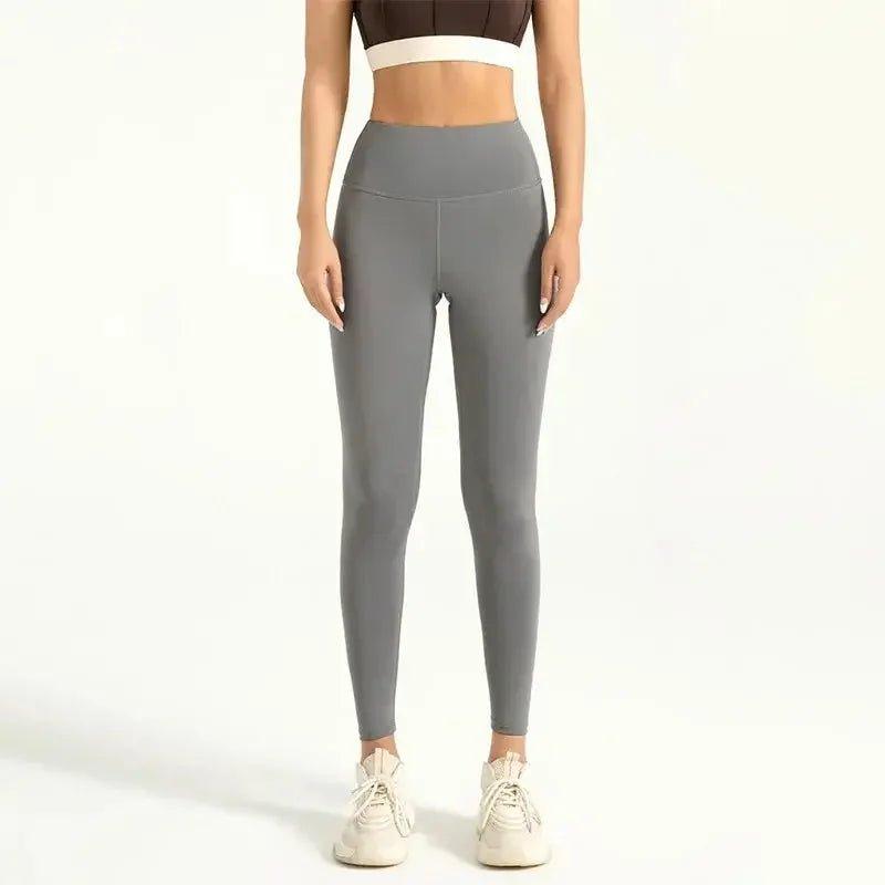 Grey high-waisted leggings for women, paired with sports bra and sneakers, ideal for fitness and casual wear.
