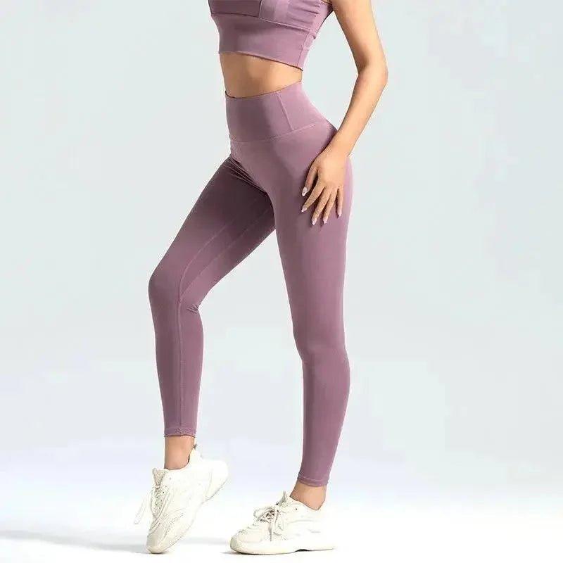 Women's mauve high-waisted leggings with matching crop top and white sneakers, fitness fashion